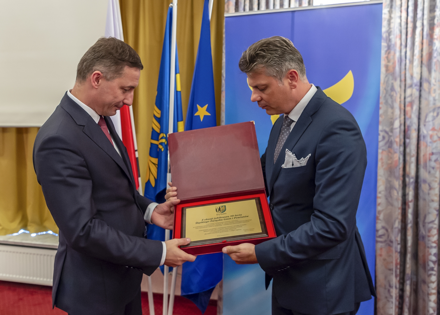 Prezydent Mariusz Wołosz przekazujący okolicznościową tabliczkę przewodniczącemu związku Piotrowi Kuczerze